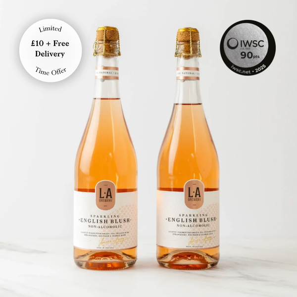 Two bottles of L.A. Brewery Sparkling English Blush non-alcoholic wine on a white background with IWSC 90+ points badge.